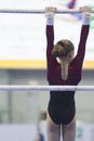 Female athlete gymnasts hanging on the bar at the championship