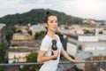 Female athlete holding sports bottle near roof handrails