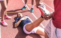 Female athlete injured on athletic run training - Male coach taking care on woman having fatigue cramps - Sport team concept