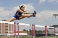 Female Athlete Jumping Over A Hurdles