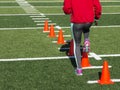 Female athlete performing running drills over cones