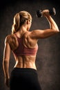Female Athlete Performing Single Arm Dumbbell Lift Highlighting Functional Strength Royalty Free Stock Photo