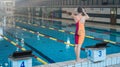 Female athlete preparing for a dive start and jumping into the pool Royalty Free Stock Photo