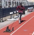Female athlete pulling a sled with weights down a track