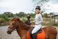 female athlete riding horse to train with male athlete Royalty Free Stock Photo