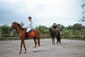 female athlete riding horse to train with male athlete Royalty Free Stock Photo