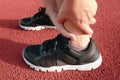 Female Athlete Runner Ankle Injury While Jogging in Running Track, Sport Woman Having Pain Her Ankles During Exercise Running.