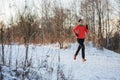 Female athlete running in winter park on morning run Royalty Free Stock Photo