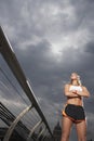 Female athlete standing on foot bridge low angle view