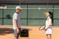 Female athlete standing in front of male coach. Sports woman talking to tennis partner. Tennis game instructor giving Royalty Free Stock Photo