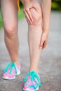 Female athlete suffering from pain in leg while exercising outdoors. Runner injury - hurting knee pain.