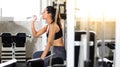 Female athlete taking rest and drinking woter after exercising at gym. Fitness Healthy lifestye and workout at gym concept Royalty Free Stock Photo