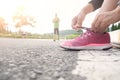 Female athlete tying laces for jogging on road Royalty Free Stock Photo