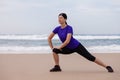 Female athlete warming up and stretching the legs before running at the beach Royalty Free Stock Photo