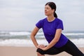 Female athlete warming up and stretching the legs before running at the beach Royalty Free Stock Photo