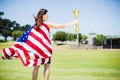 Female athlete wrapped in american flag holding fire torch Royalty Free Stock Photo