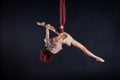 Female athletic, sexy and flexible aerial circus artist with redhead dancing in the air on the silk Royalty Free Stock Photo