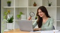 Female Auditor with magnifying glass checking online content on laptop computer Royalty Free Stock Photo