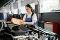 Female auto mechanic changing engine air filter in car Royalty Free Stock Photo