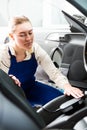 Female mechanic metering color of car upholstery