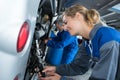 Female auto mechanic smiling repairing bus