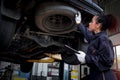 Female auto mechanic work in garage, car service technician woman check and repair customer car at automobile service center, Royalty Free Stock Photo