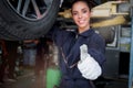 Female auto mechanic work in garage, car service technician woman give thumb up, repair customer car at automobile service center Royalty Free Stock Photo