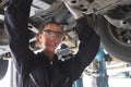 Female auto mechanic working in garage, car service technician woman checking and repairing the customerÃ¢â¬â¢s car at automobile Royalty Free Stock Photo