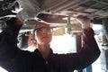 Female auto mechanic working in garage, car service technician woman checking and repairing the customerÃ¢â¬â¢s car at automobile Royalty Free Stock Photo