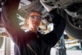 Female auto mechanic working in garage, car service technician woman checking and repairing the customerÃ¢â¬â¢s car at automobile Royalty Free Stock Photo