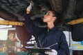 Female auto mechanic working in garage, car service technician woman checking and repairing the customerÃ¢â¬â¢s car at automobile Royalty Free Stock Photo