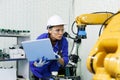 female automation machine engineer student study and inspection control robot arm machine in university or factory workshop. ai