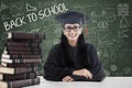 Female bachelor and books in class Royalty Free Stock Photo