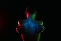 Female back in Colorful bright lights. Beautiful Naked body silhouette