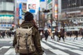 female with a backpack crossing shibuya crossing