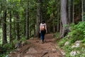 Female with a backpack on a hiking trail in the forest