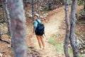 Female with backpack trekking on mountains, walking and running through forest and hills. Happy woman, ready for adventure
