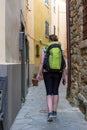 Female backpacker exploring narrow streets of medieval town.