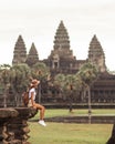 Female Traveler At Angkor Wat, Sitting By Moat, Cambodia Travel Concept Royalty Free Stock Photo