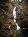 Female Backpacker with orange backpack exploring waterfalls
