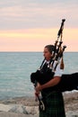 Female Bagpiper on the Pier at Sunset Royalty Free Stock Photo