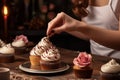 Female baker decorating cupcake. Generate Ai Royalty Free Stock Photo