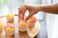 A female baker decorating her beautiful homemade cupcake with tiny white chocolate ball Royalty Free Stock Photo