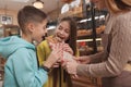 Female baker helping her young customers Royalty Free Stock Photo