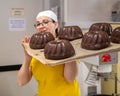 Female baker holding a tray of freshly-baked chocolate bundt cakes