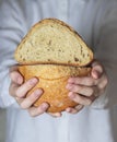 Female baker holds home made artisan organic bread fresh from the oven. Homemade sourdough bread. Homemade food Royalty Free Stock Photo