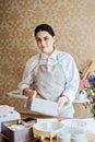 Female baker, pastry chef preparing cake order. Arabic Asian woman making cake for online delivery Royalty Free Stock Photo