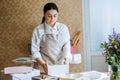 Female baker, pastry chef preparing cake order. Arabic Asian woman making cake for online delivery Royalty Free Stock Photo