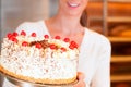 Female baker or pastry chef with torte