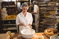 Female baker sifting flour through a sieve Royalty Free Stock Photo